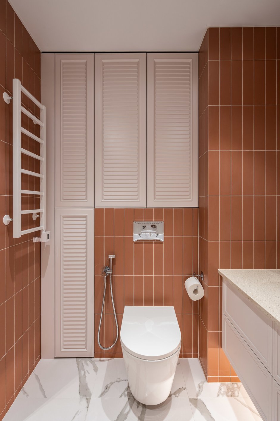 В ванной же есть фасады под жалюзи, которые оттеняют объемную плитку и поддерживают цветовой баланс.