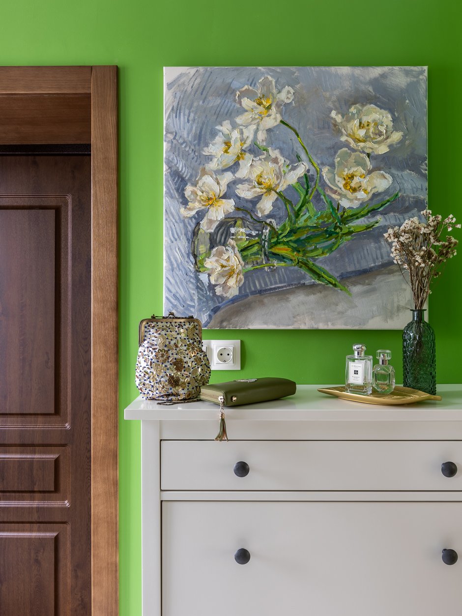 При входе в дом повесили нежную цветочную картину Елены Островской, которая успокаивает яркие стены тамбура и перекликается с другими цветочными орнаментами в доме.