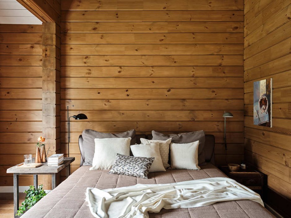 В мастер-спальне удачно соседствуют современная кровать в обивке из экокожи и прикроватные тумбы, сделанные на заказ частным мастером.