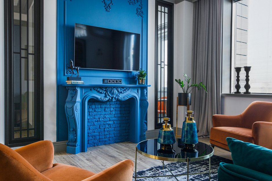 Акцент всей квартиры — это декоративный камин сложного синего цвета. Элементы лепнины выполнены локально. 
