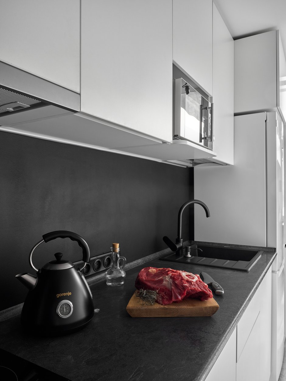Кухня в коридоре, на фартуке просто моющаяся черная краска, которая отлично эксплуатируется. Гарнитур выполнен полностью из ЛДСП.