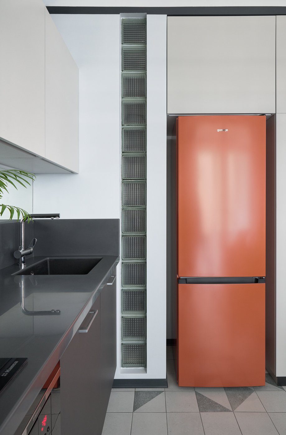 Холодильник радует своим ярким цветом, он встроен в нишу, образованную стеной и шкафом.