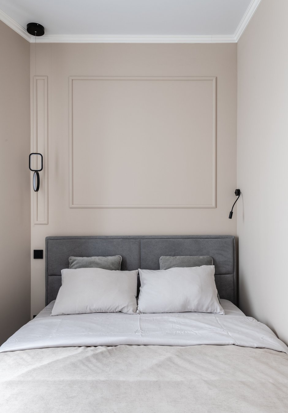 Дизайнер подчеркнула асимметрию комнаты раскладкой молдингов в изголовье и разными светильниками с двух сторон от кровати.