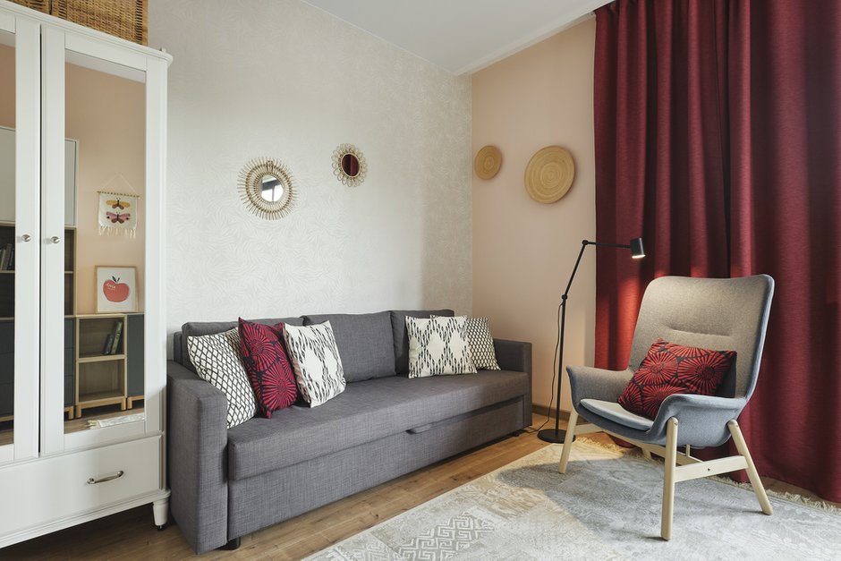 В гостевой комнате обои однотонные нежного персикового цвета, в изголовье дивана обои с легким растительным принтом, поддерживающим идею всей квартиры.
